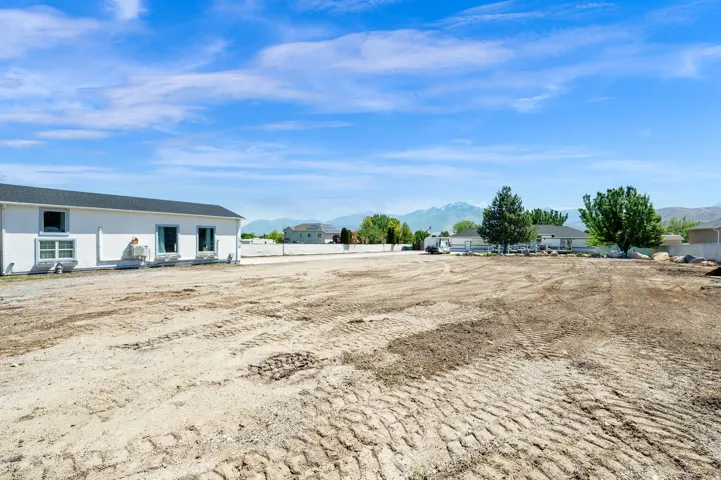 Expansive open lot featuring a clear, level terrain and a backdrop of distant mountains