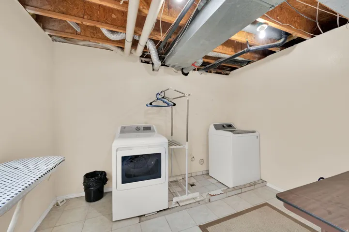 Laundry area featuring light-toned walls and tiled flooring