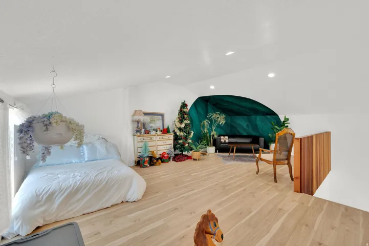 Photo Studio LOFT - Spacious loft area featuring light wood-finish flooring, white walls, and a distinctive emerald accent wall