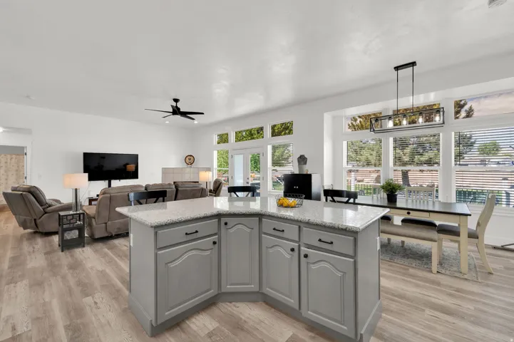Central kitchen island with a light-toned countertop, grey cabinetry, and dark hardware