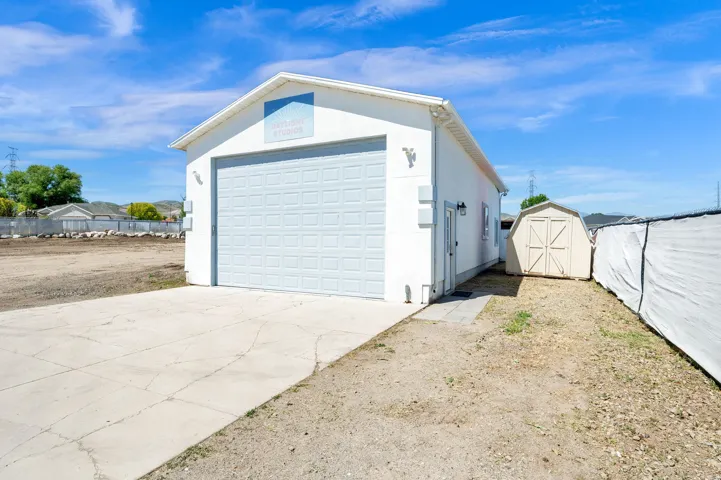 Photo Studio - currently rented on a month to month. Detached white 2 car finished garage 24 x 42" with upper loft. a large 12'  light gray garage door, a side entry door, and exterior lighting fixtures