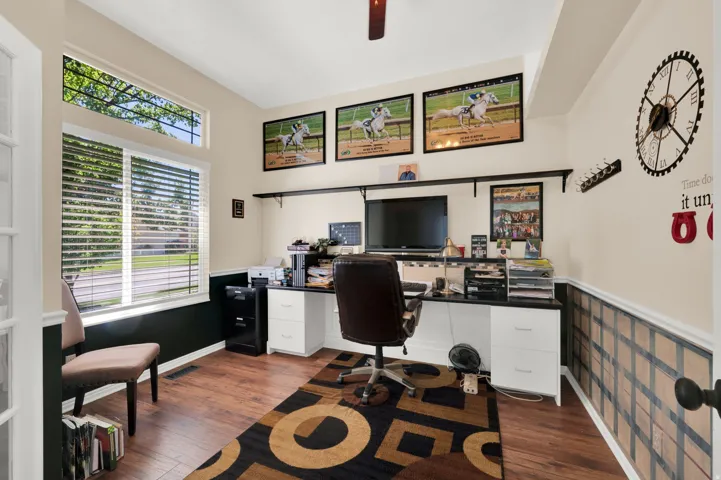 Dedicated room with wood-finish flooring and a prominent window assembly featuring a large lower pane and an upper transom window