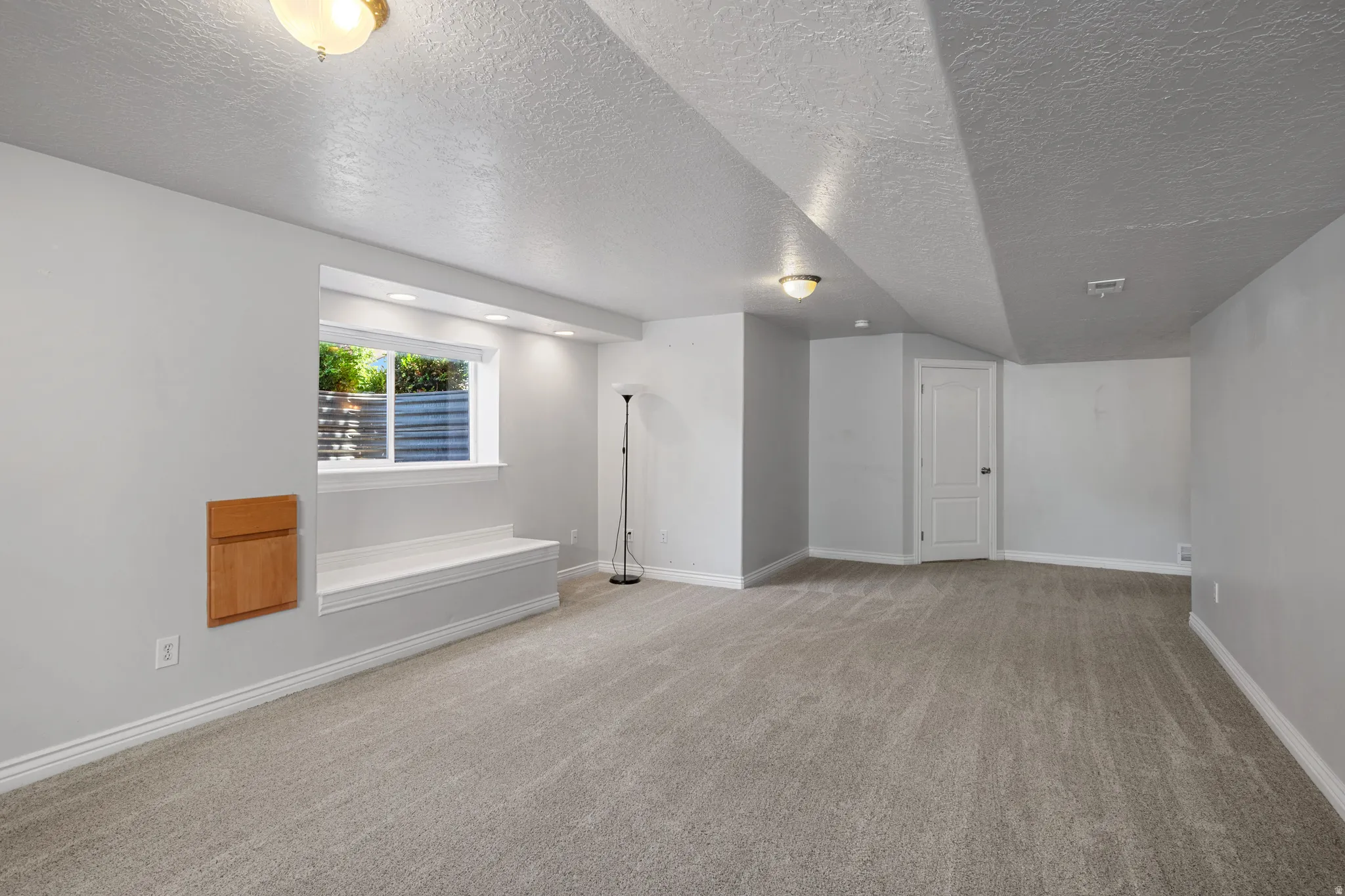 Spacious room featuring neutral carpeting and light gray walls