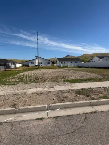 Cleared lot with partial curb and sidewalk infrastructure