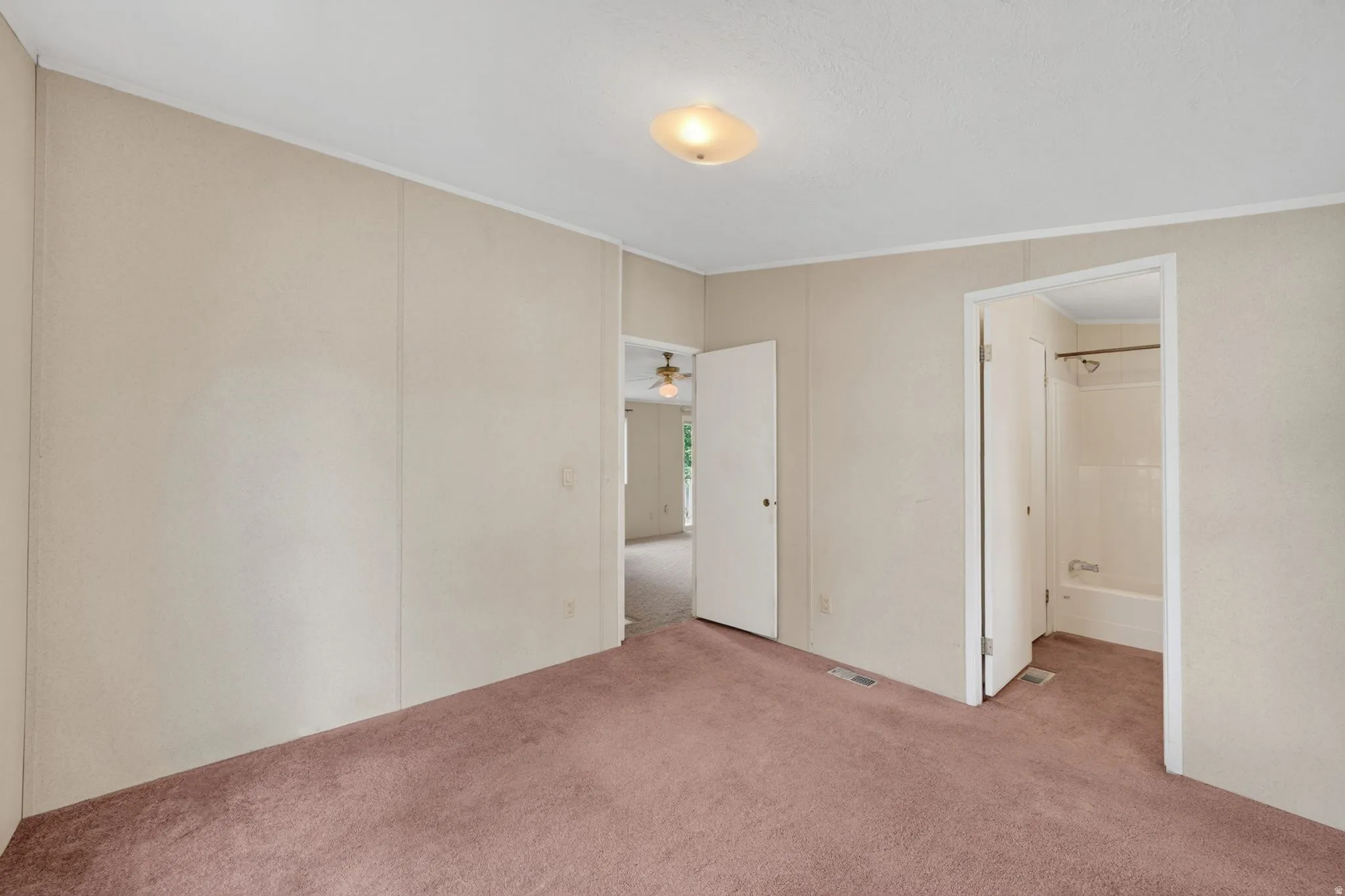 Carpeted room featuring light-colored panel walls and a ceiling-mounted light fixture