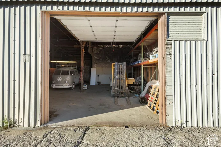 Industrial-style corrugated metal exterior featuring a large bay door opening to an expansive interior space