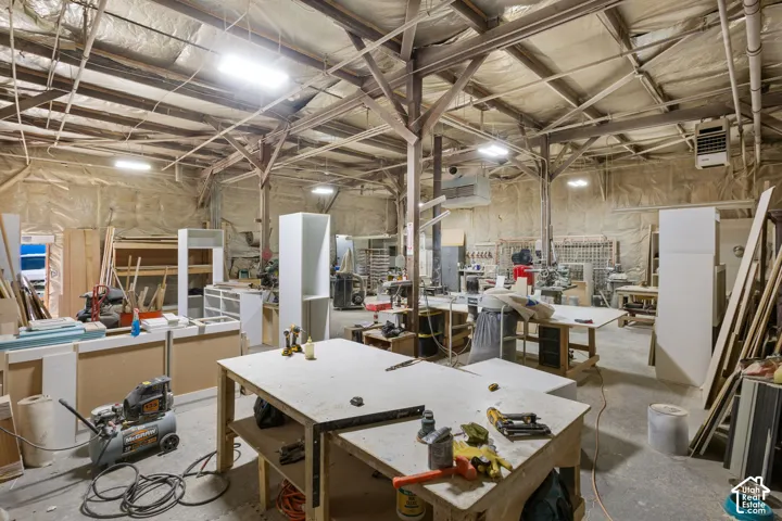 Spacious industrial interior featuring exposed wood beams and ceiling insulation