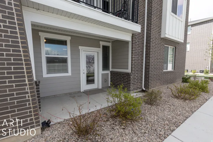 Exterior entry featuring a concrete patio, white framed glass door, and a white framed window