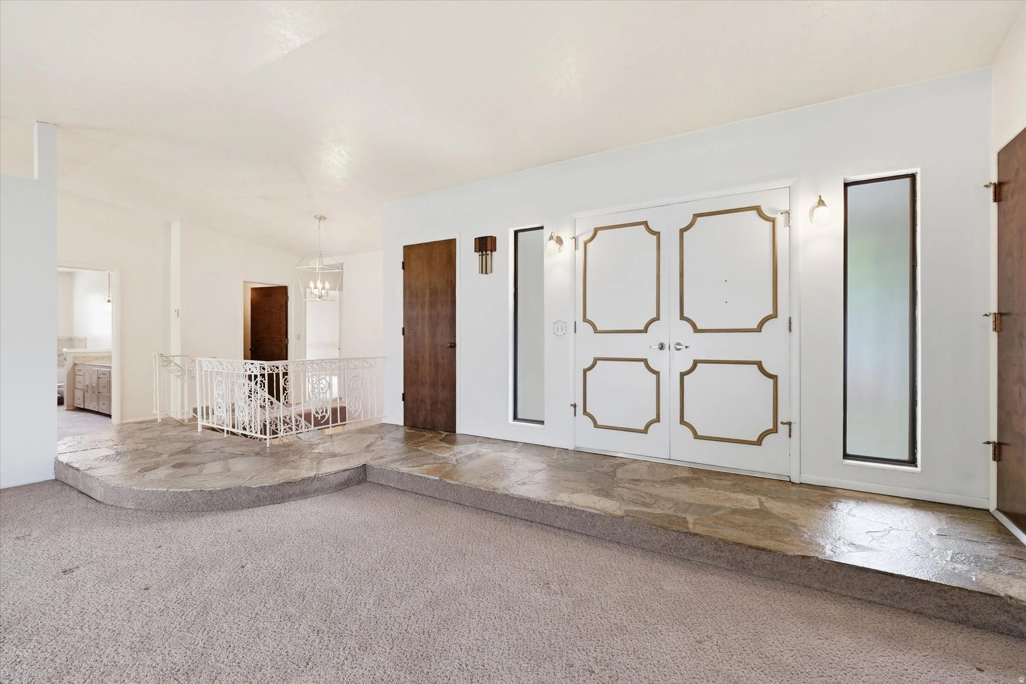 Entryway featuring double doors with decorative gold trim, flanked by vertical windows