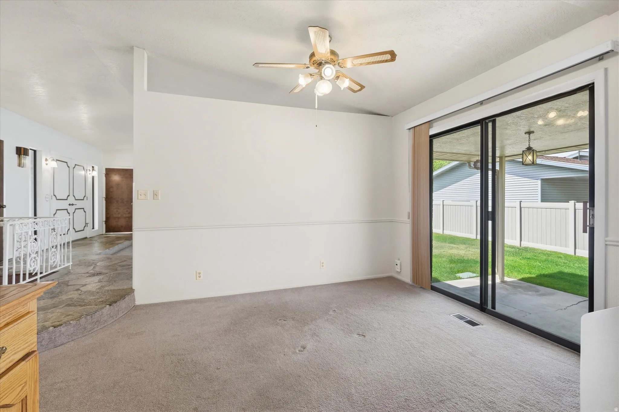 Interior space featuring light-toned carpeting and a ceiling fan with integrated lighting