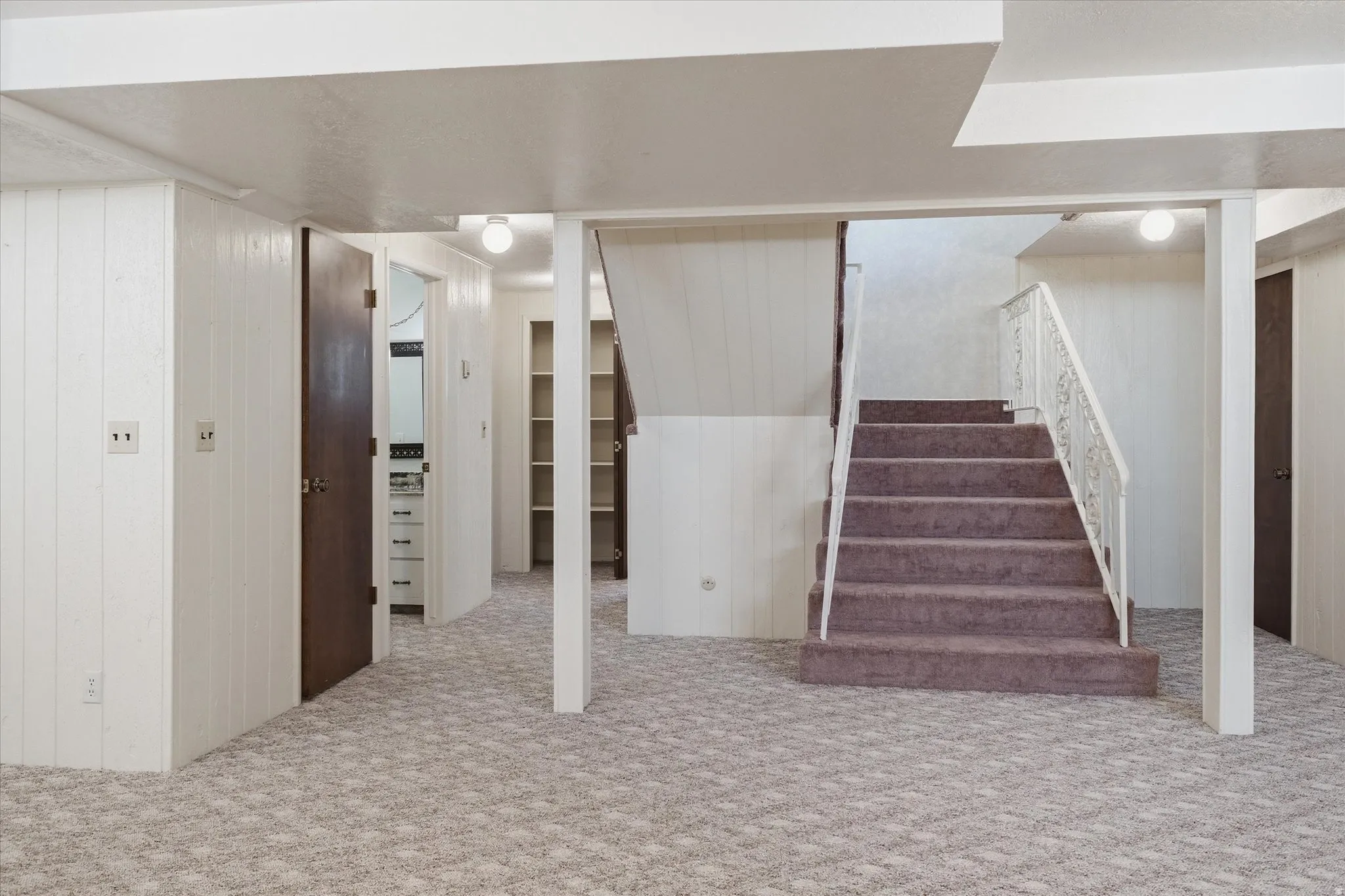 Carpeted staircase with an ornate white railing