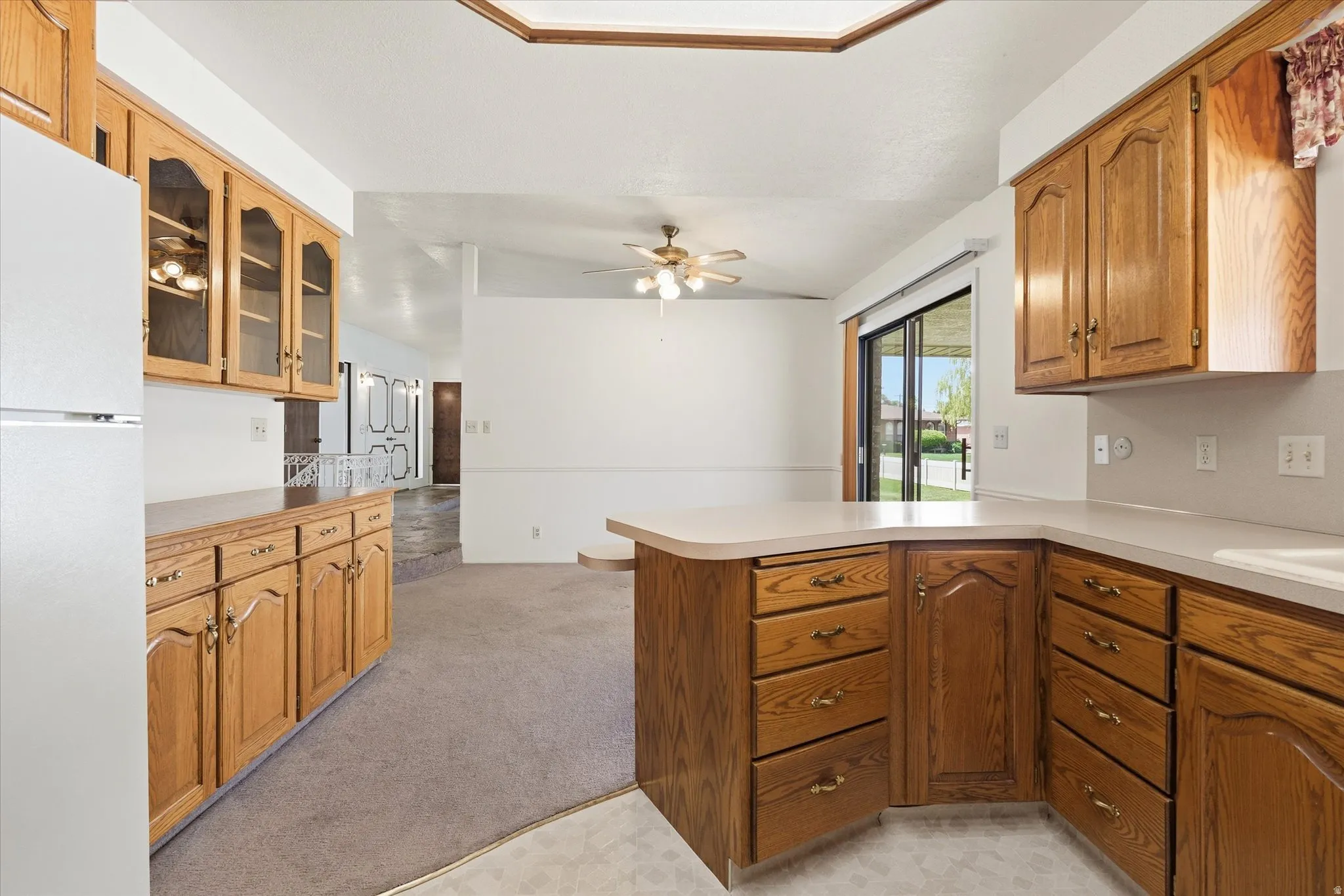 Kitchen featuring wood-finish cabinetry, solid surface countertops, and a built-in refrigerator