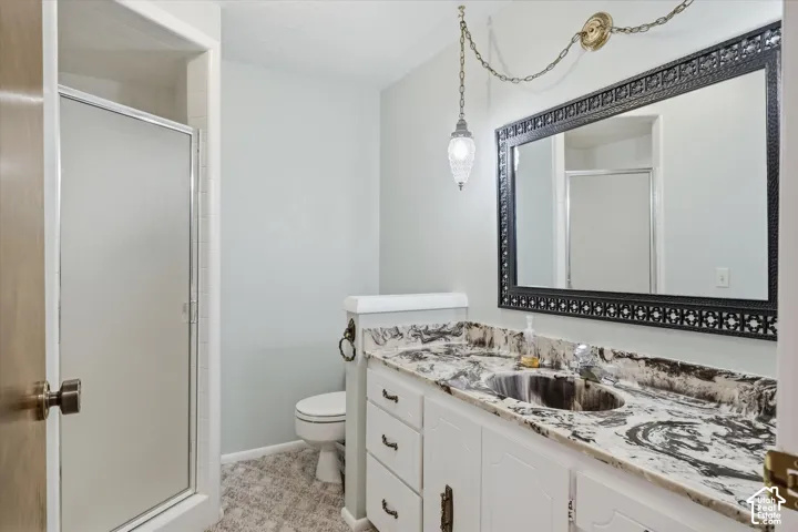 Bathroom vanity featuring a patterned countertop with integrated sink, white cabinetry, and an ornate framed mirror
