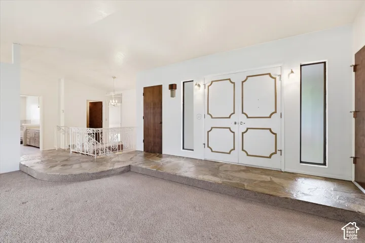 Entryway featuring double doors with decorative gold trim, flanked by vertical windows