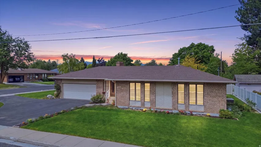 Single-story brick exterior with a low-pitch roof, an attached garage, and a concrete driveway