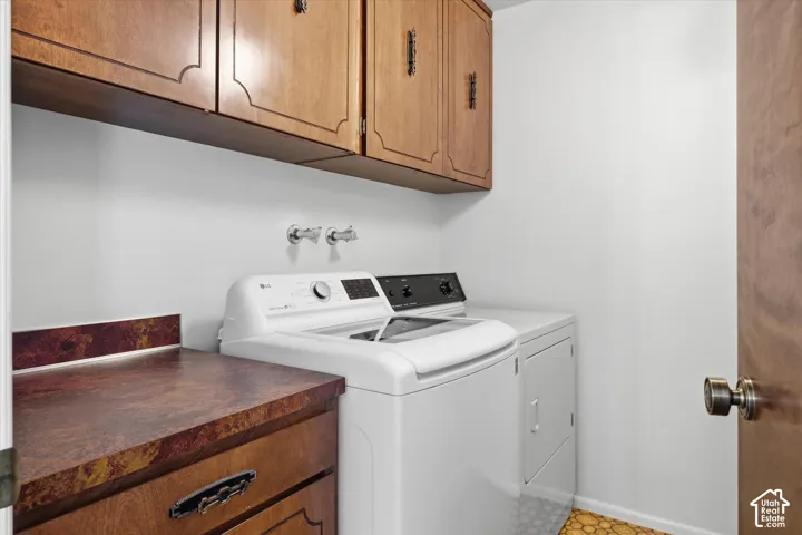 Laundry area with overhead wood cabinetry, a built-in countertop, and a wood-finish door