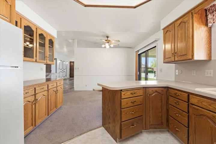 Kitchen featuring wood-finish cabinetry, solid surface countertops, and a built-in refrigerator