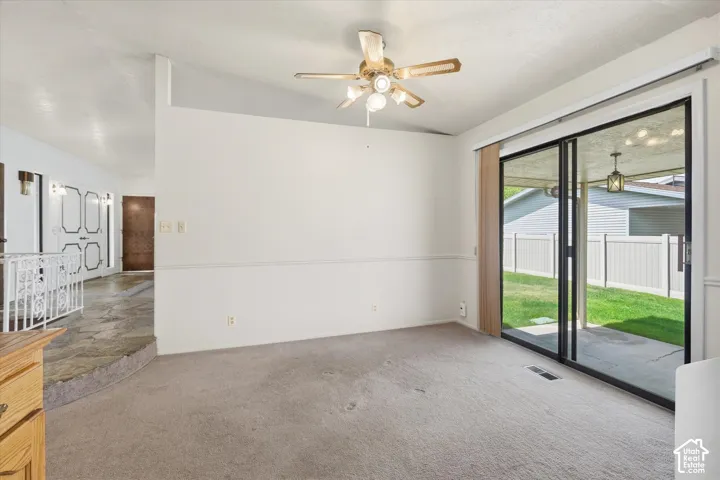 Interior space featuring light-toned carpeting and a ceiling fan with integrated lighting