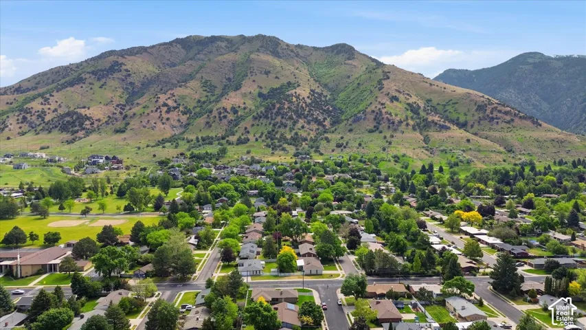 Expansive neighborhood setting featuring a mountainous backdrop, mature trees, and residential streets