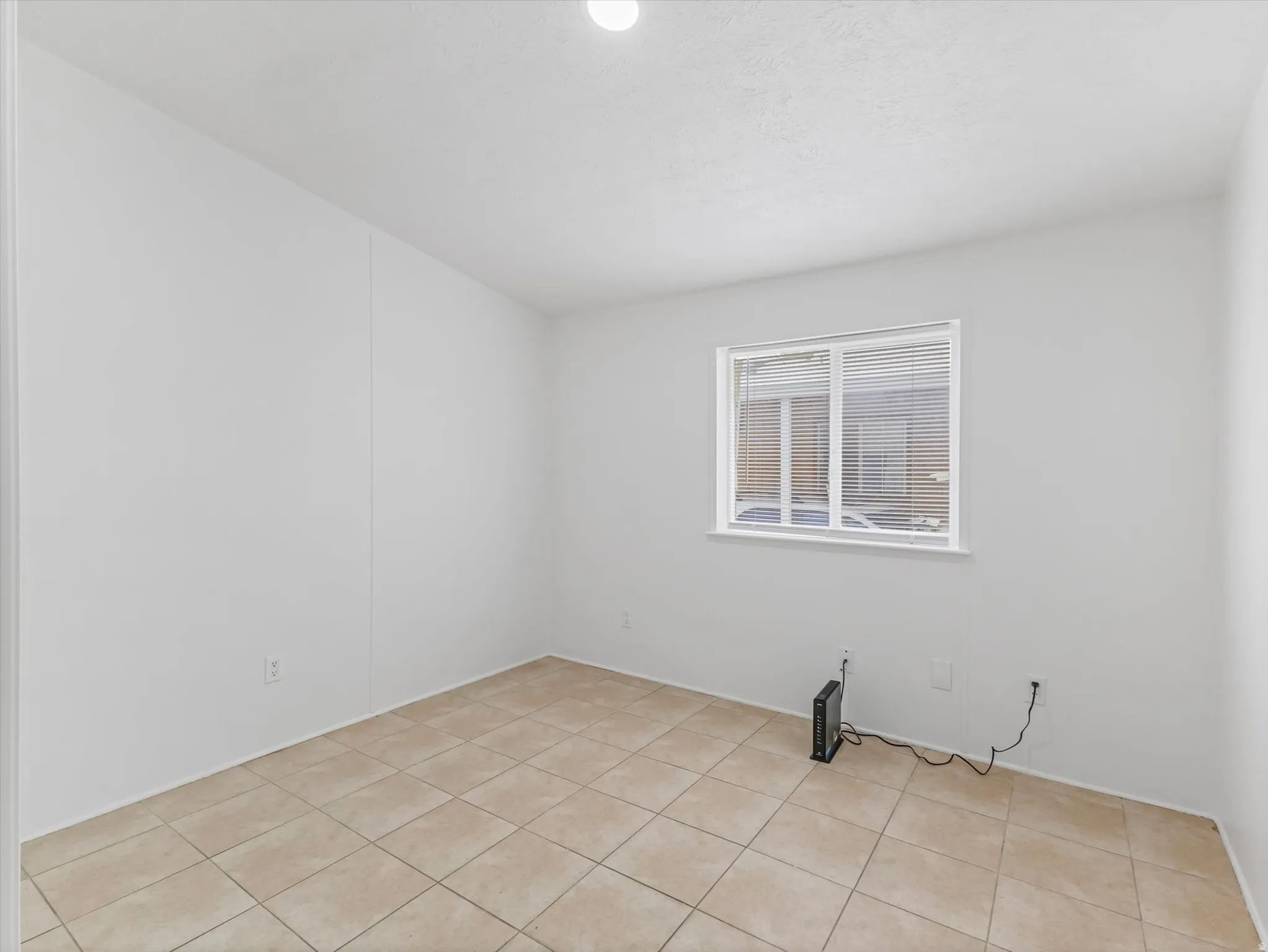 Neutral-toned tile flooring complements the white walls and ceiling