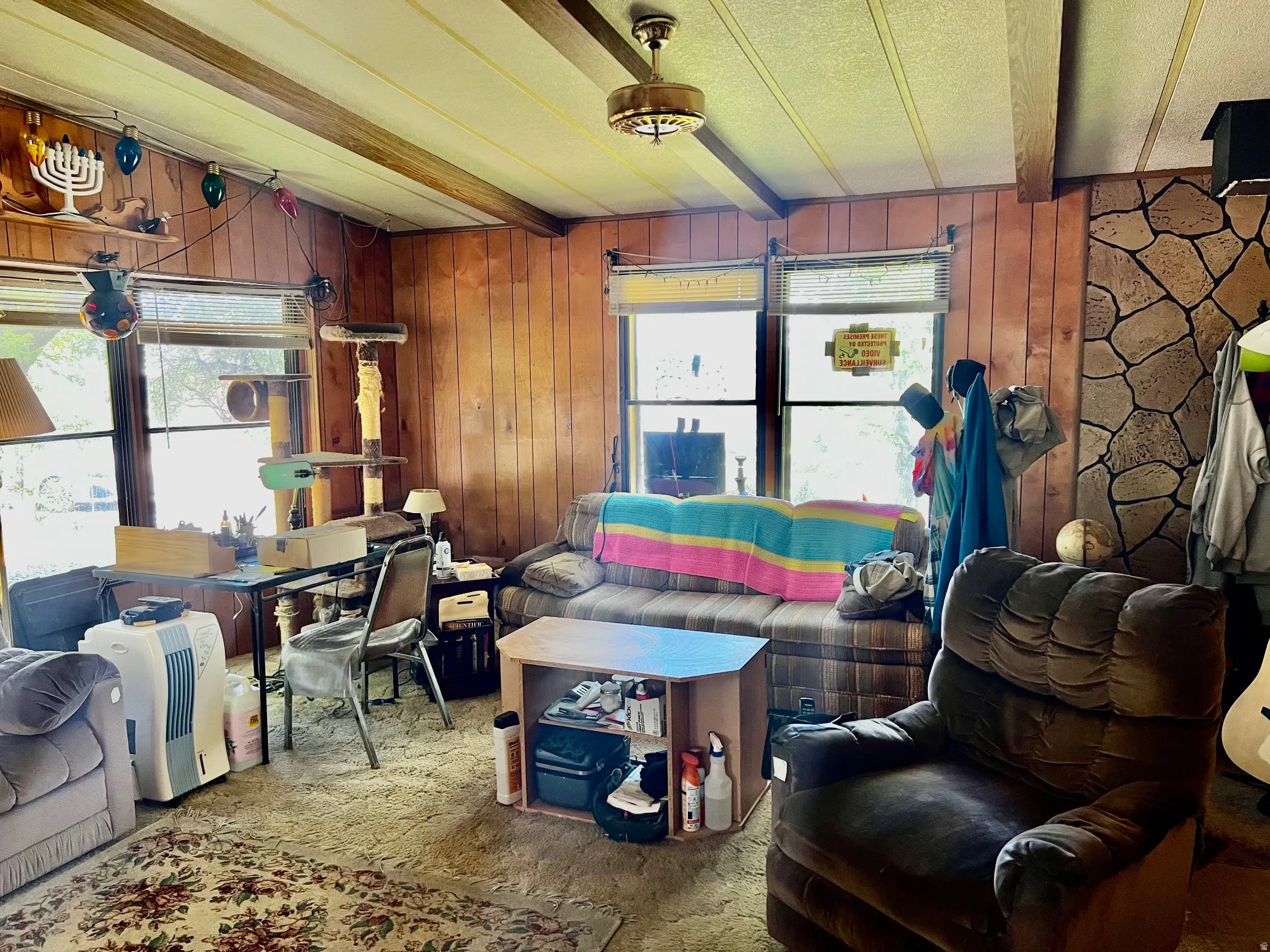 Paneling walls, exposed beam ceiling, and a stone-finish accent wall