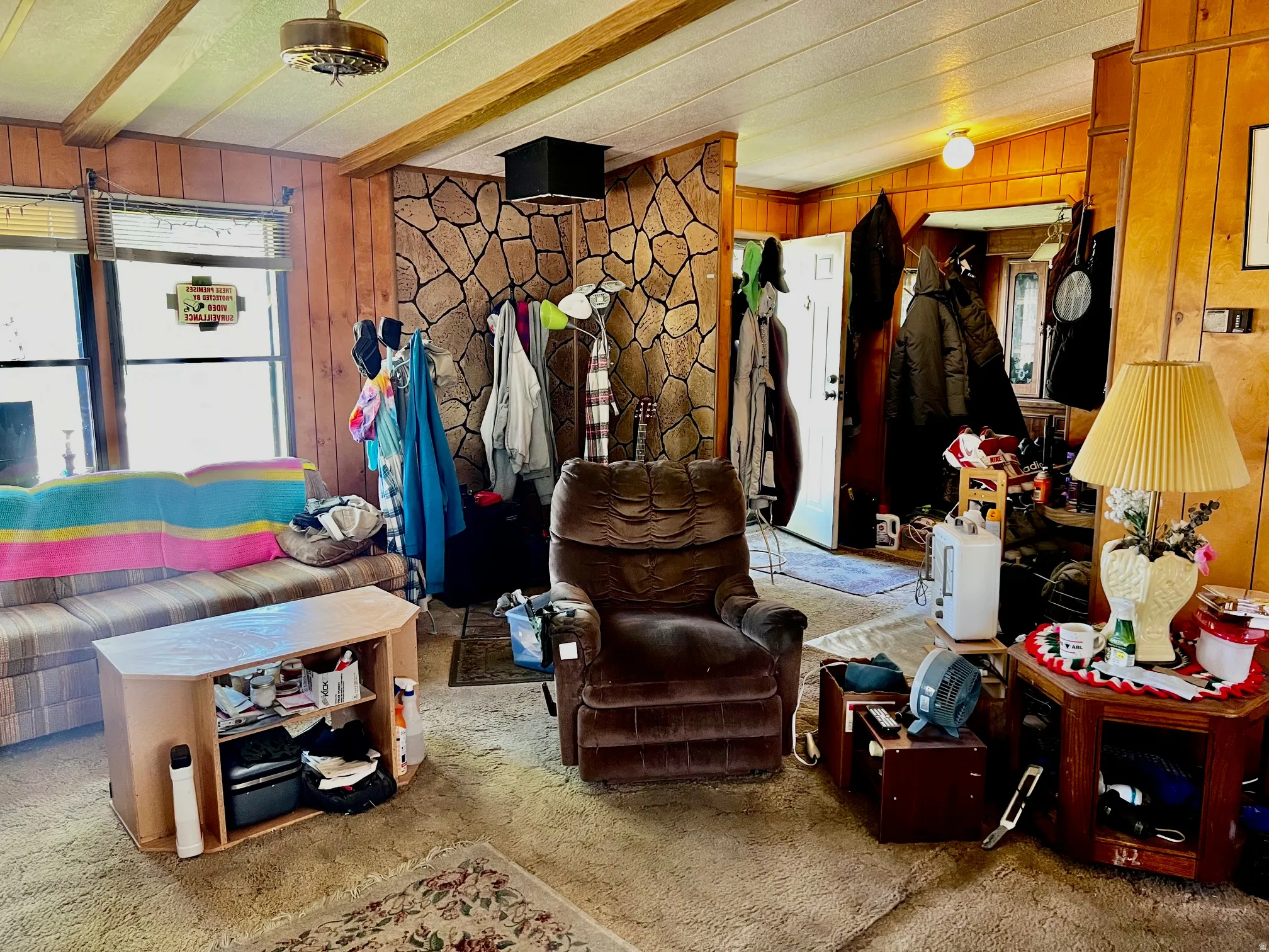 Living area featuring wood-paneled walls and a stone accent wall