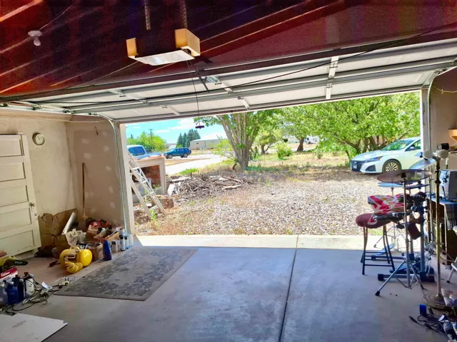 Attached garage space featuring a concrete floor, overhead lighting, and an automatic garage door opener