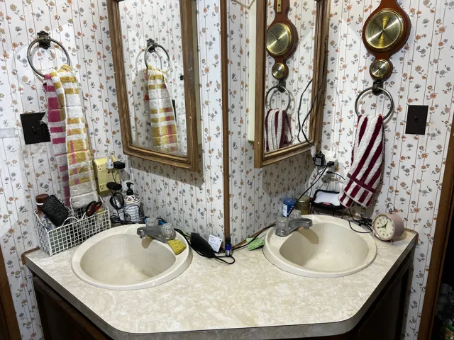 Dual vanity with integrated sinks, laminate countertop, and wood-framed mirrors