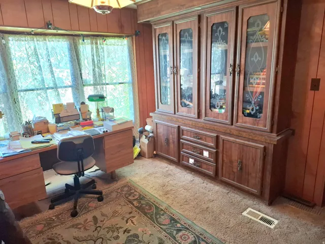 Built-in cabinetry with glass-front uppers and lower storage, wood-finish paneling, and a large window