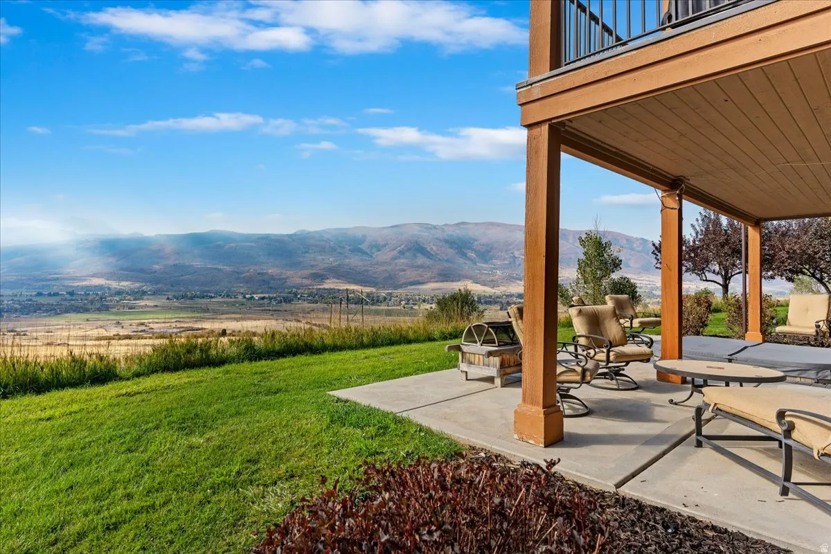 Expansive concrete patio with a covered outdoor area, supported by wood-finish columns