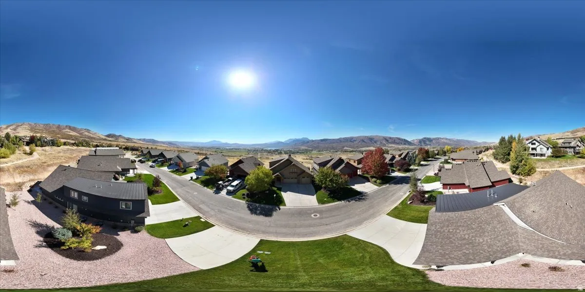 Residential street featuring a cul-de-sac, paved driveways, and landscaped front yards