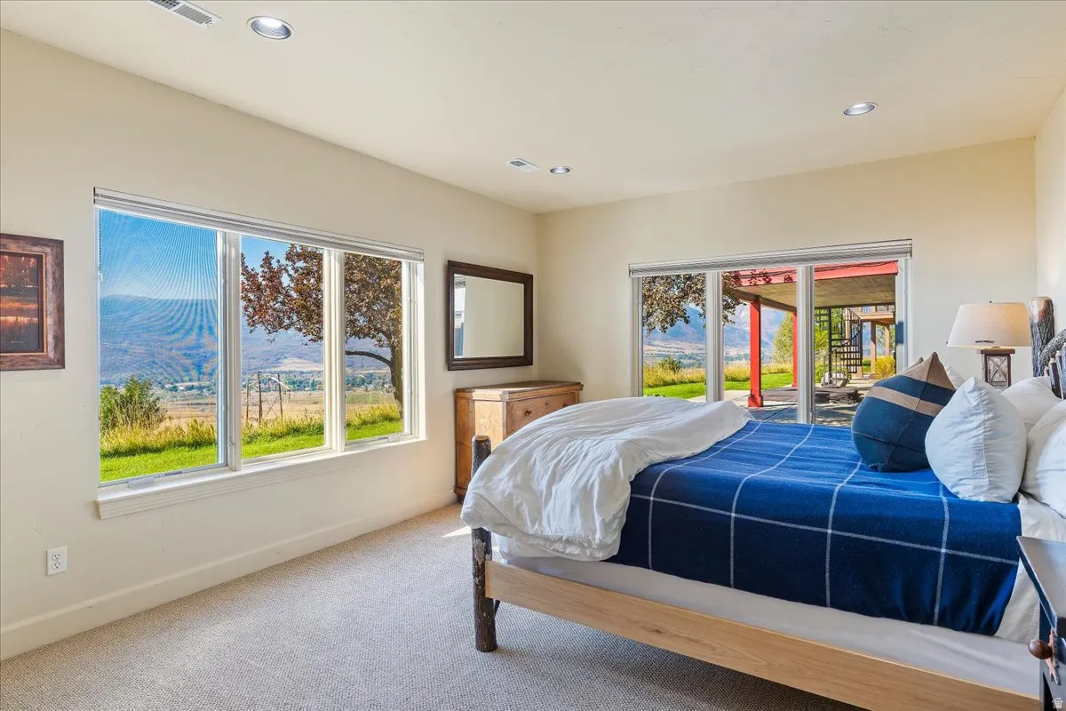 Expansive bedroom featuring light-toned walls, recessed lighting, and carpet flooring