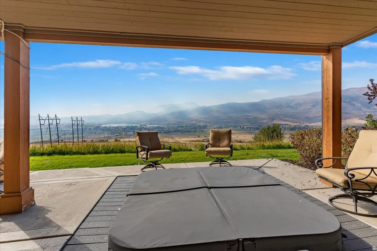 Covered patio featuring a hot tub, concrete paving, and composite decking