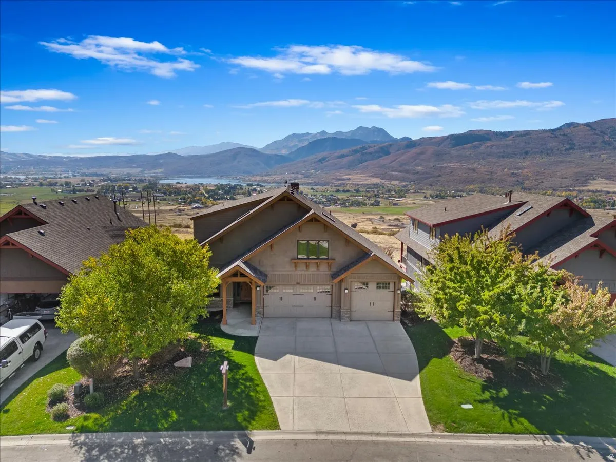 Craftsman-style residence featuring a prominent gabled roofline, stone veneer accents, and a covered entry porch with exposed wood beams