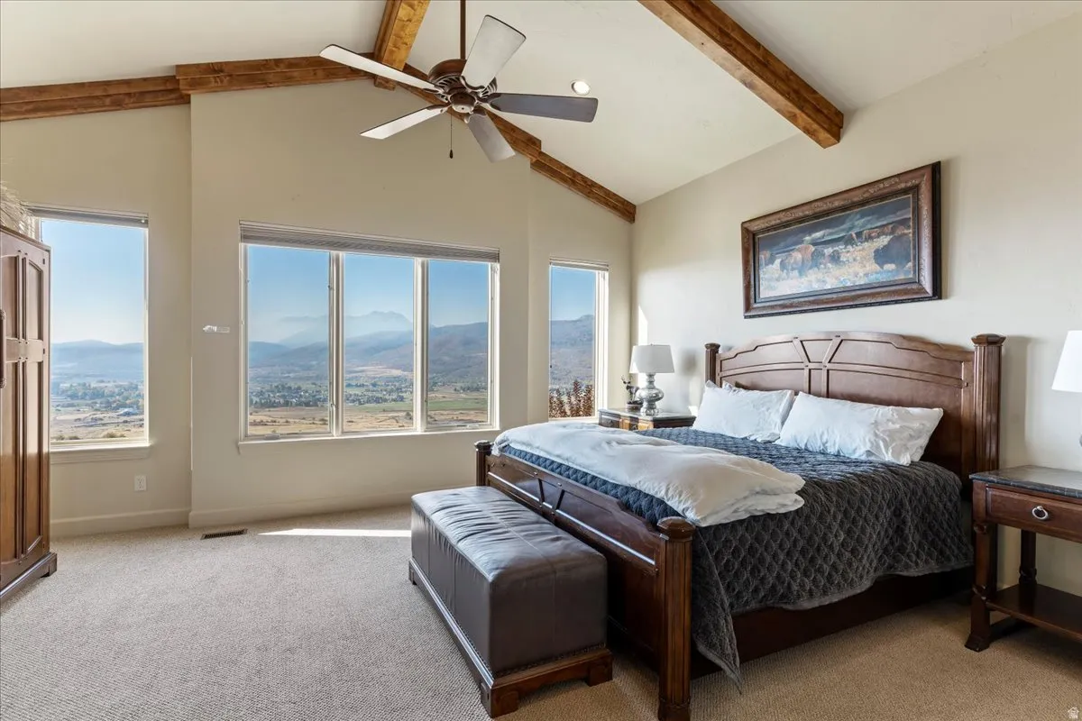 Vaulted ceiling with exposed wood beams and ceiling fan
