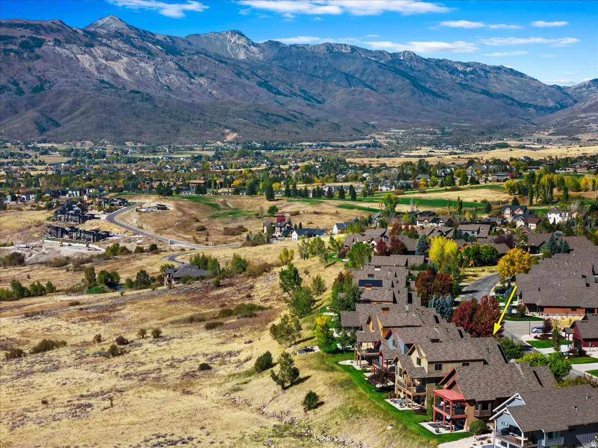 Aerial perspective showcasing a community situated at the base of a prominent mountain range