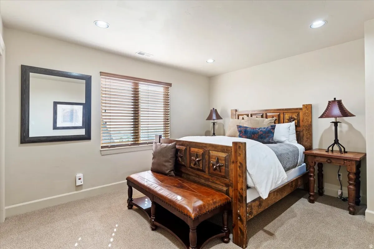Carpeted bedroom with recessed lighting, a window with wood blinds, and light-toned walls