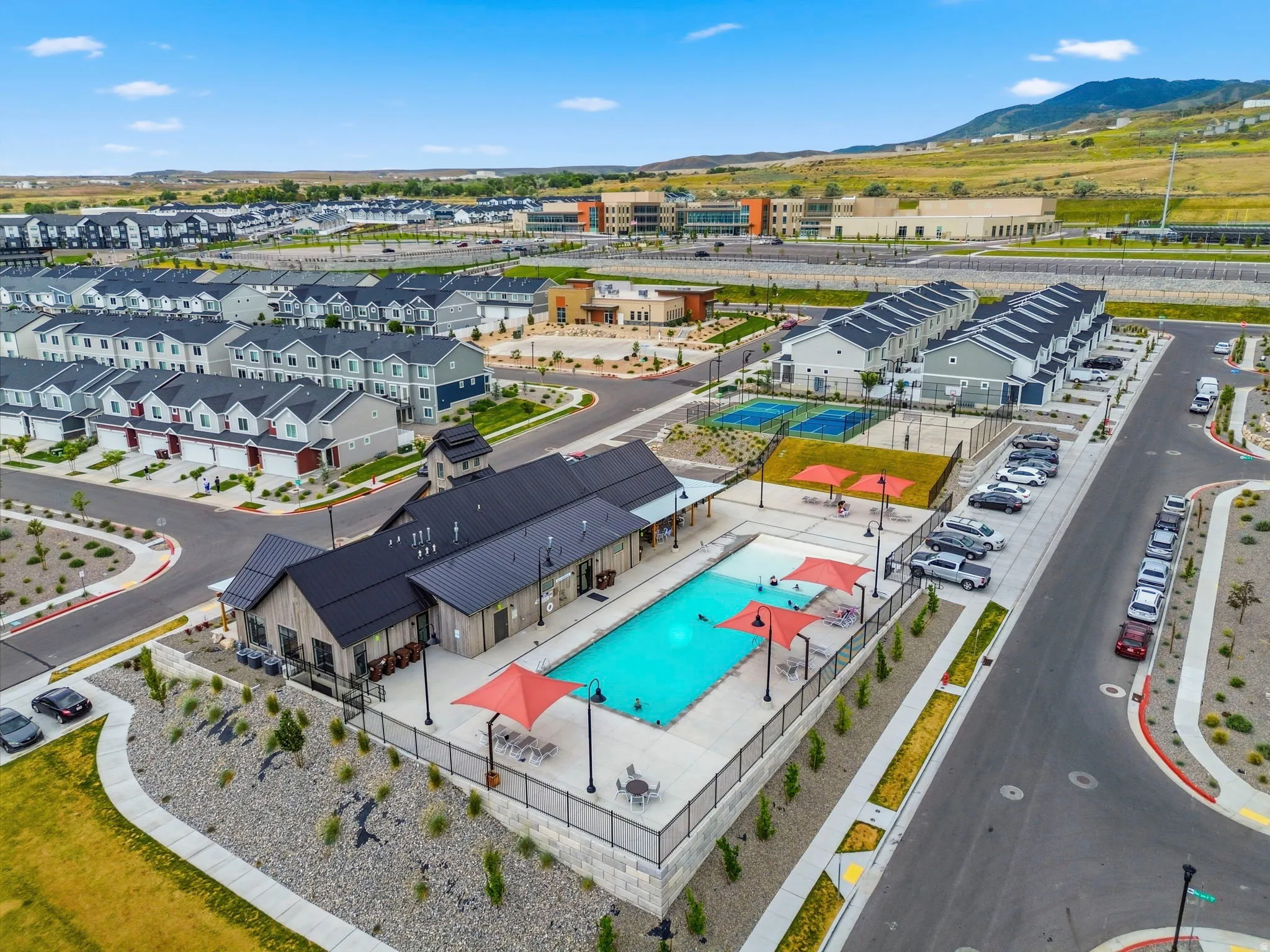 Community pool with adjacent recreational building, tennis/pickle courts, and basketball courts