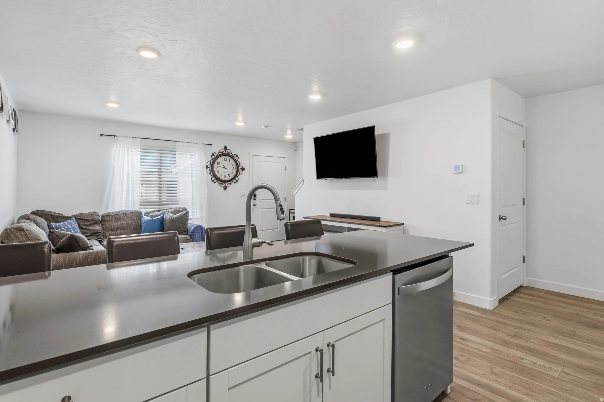 Kitchen island featuring a dual stainless steel sink, gooseneck faucet, and integrated stainless steel dishwasher