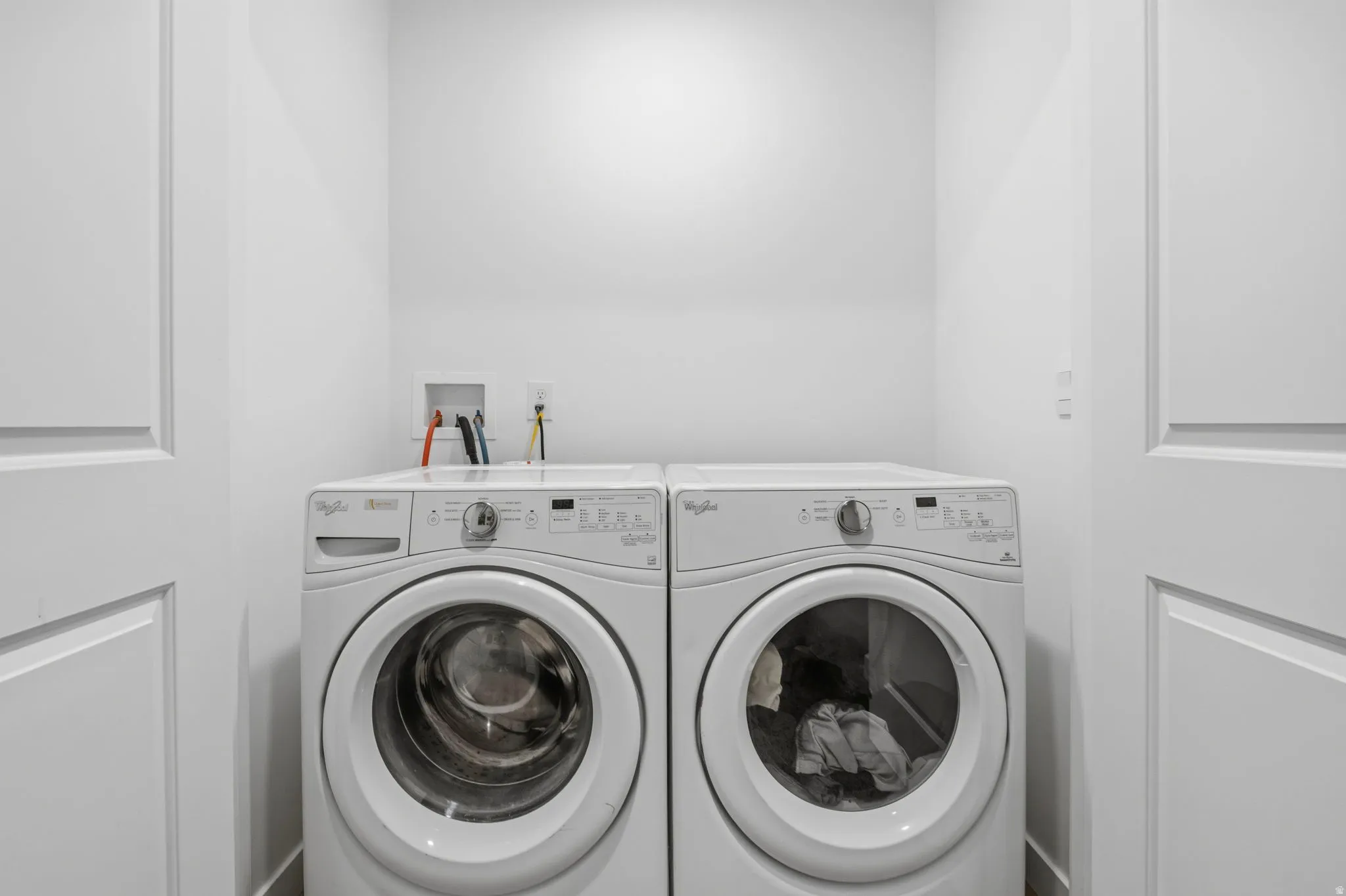 Dedicated laundry area with white walls and wood-finish flooring with Washer/Dryer