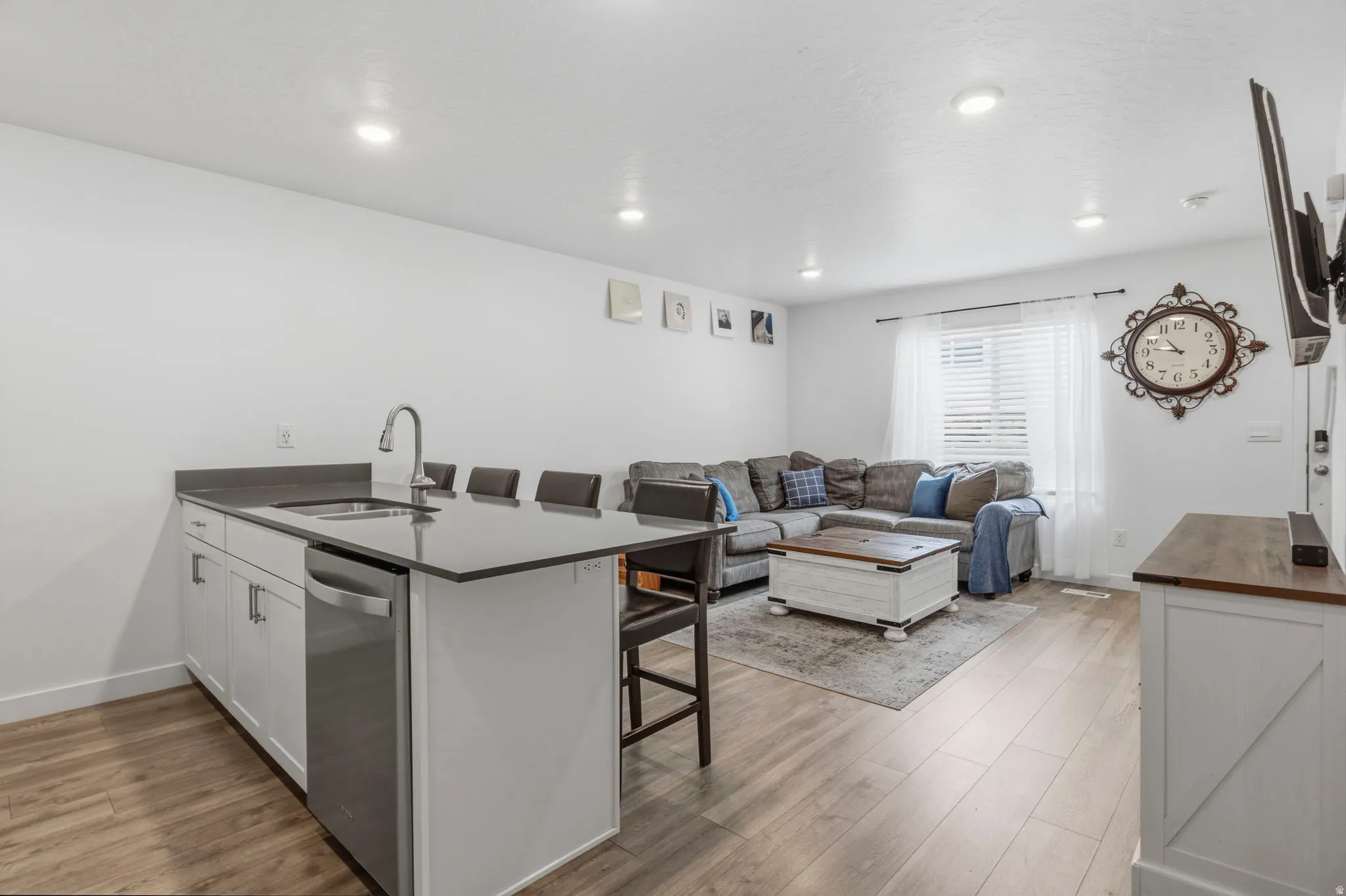 Kitchen island with an undermount sink, gooseneck faucet, and stainless steel dishwasher