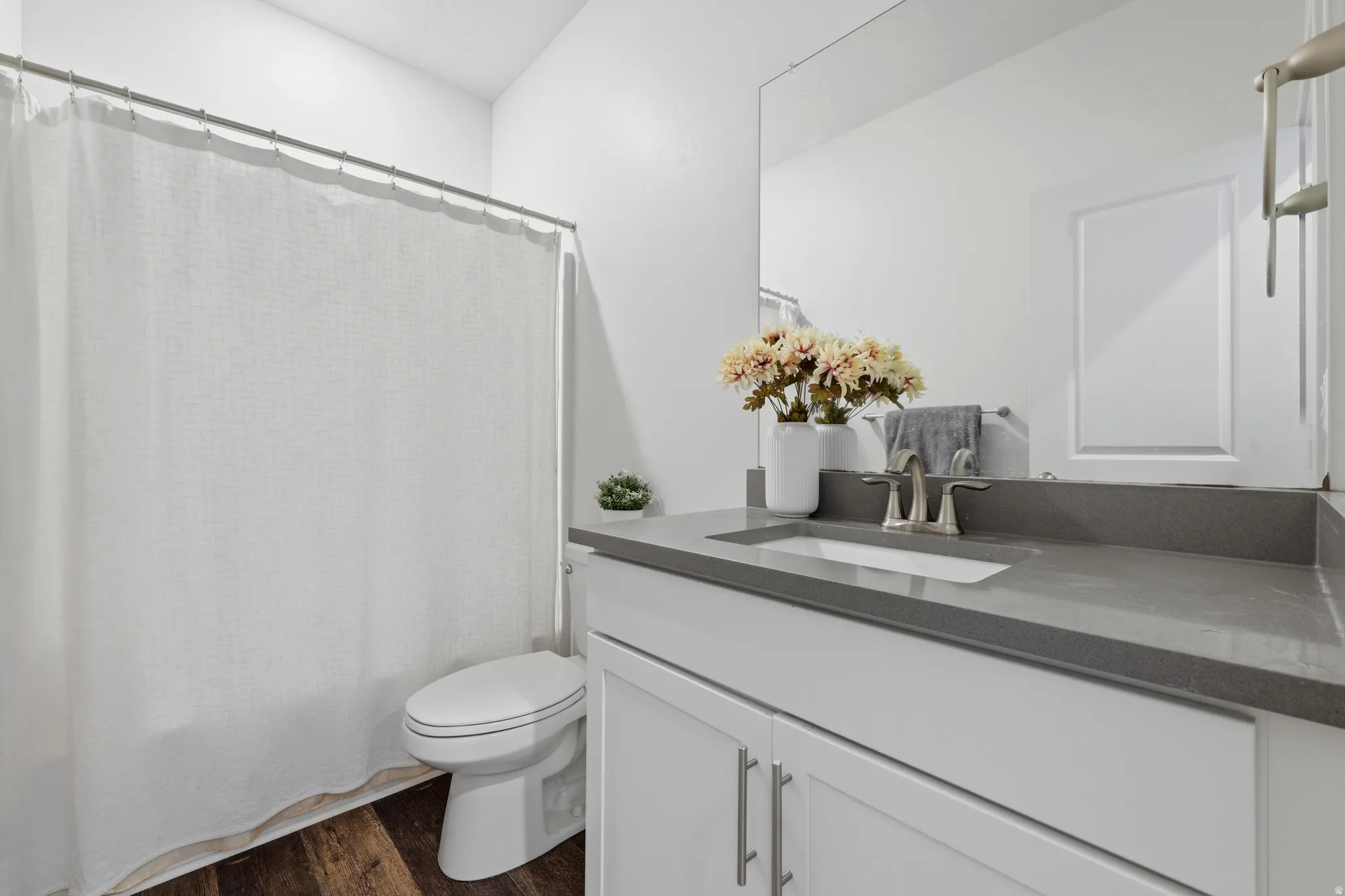 Bathroom featuring a white vanity with a gray stone-finish countertop, undermount sink, and brushed nickel faucet