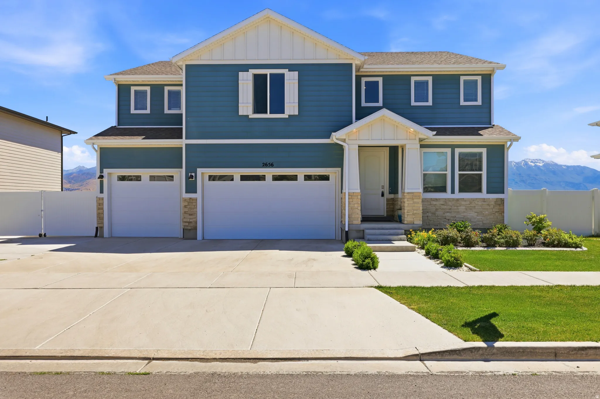 Two-story residence featuring blue siding, white trim, and a stone facade