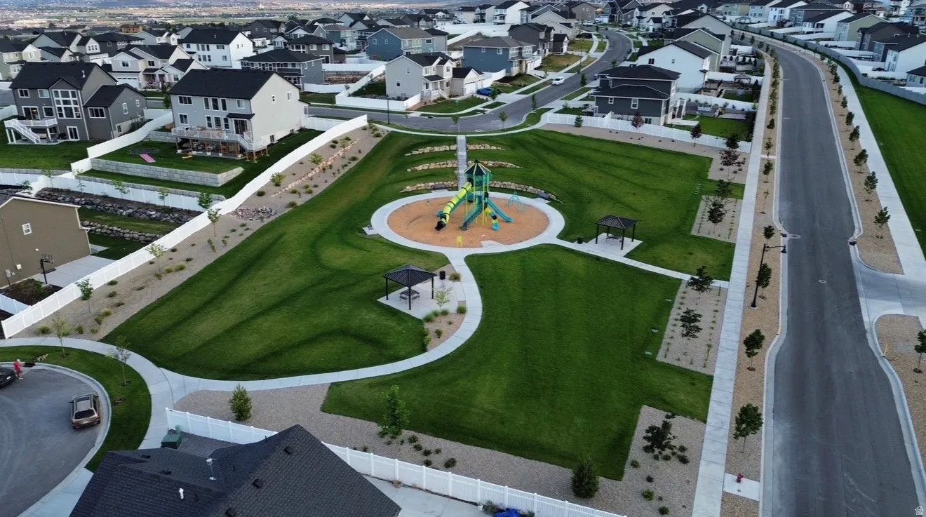 Community green space featuring a playground, walking paths, and shaded seating areas