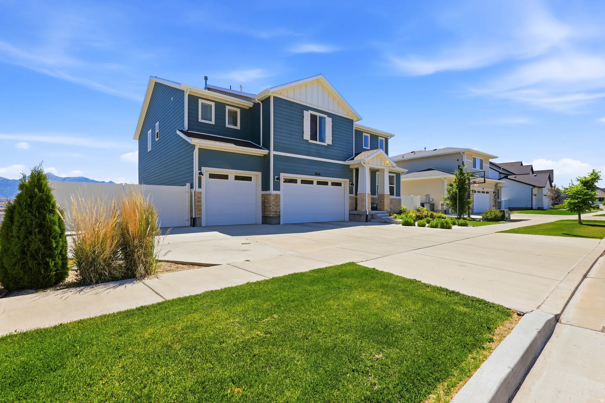 Two-story residence featuring blue siding with white trim accents and a partial stone facade
