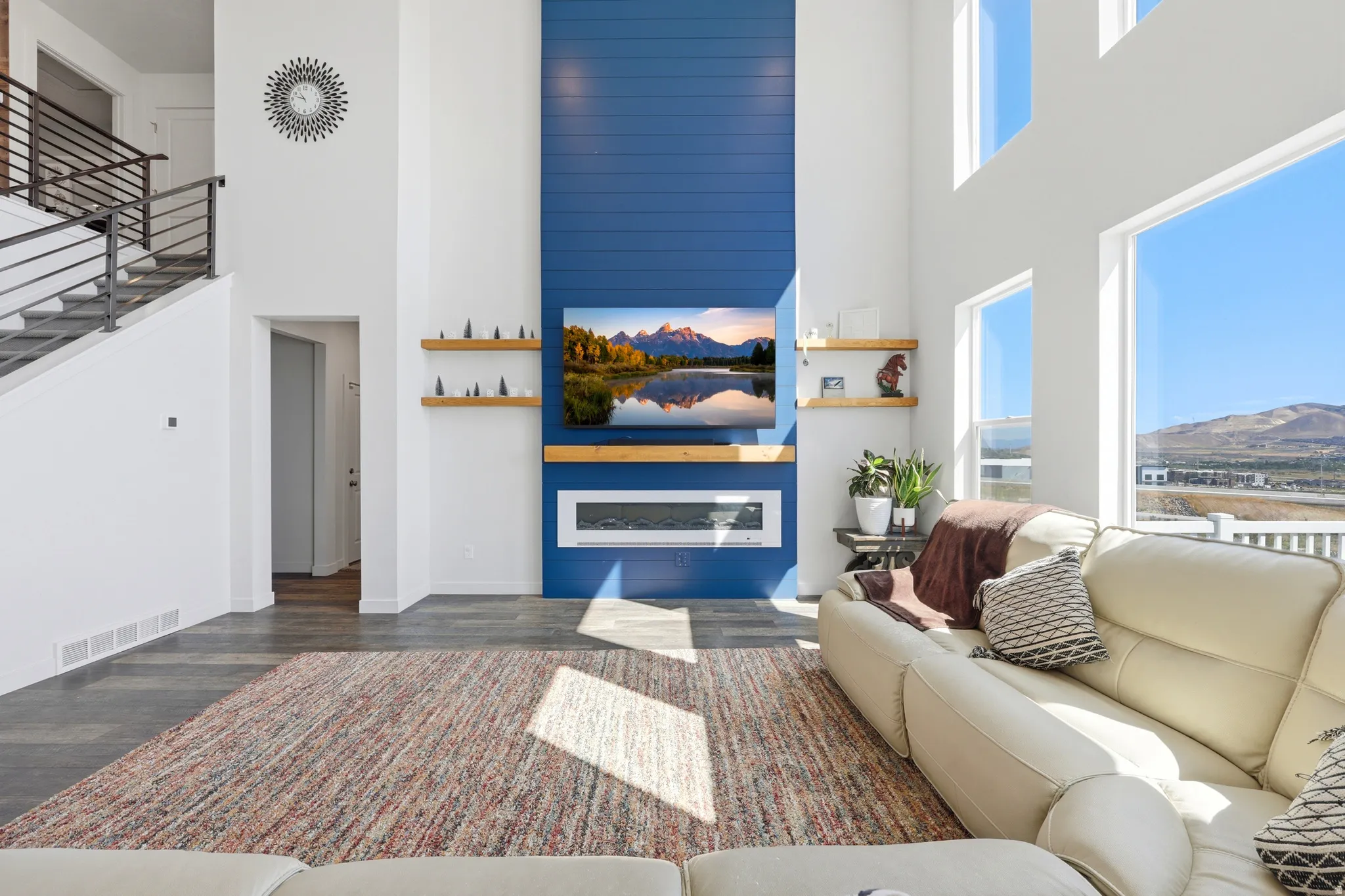 Two-story living area featuring a prominent blue shiplap accent wall with a built-in linear fireplace