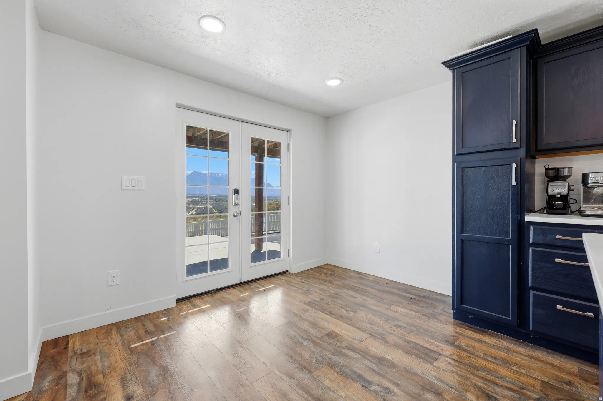 Glass-paneled French doors opening to an outdoor patio with mountain scenery