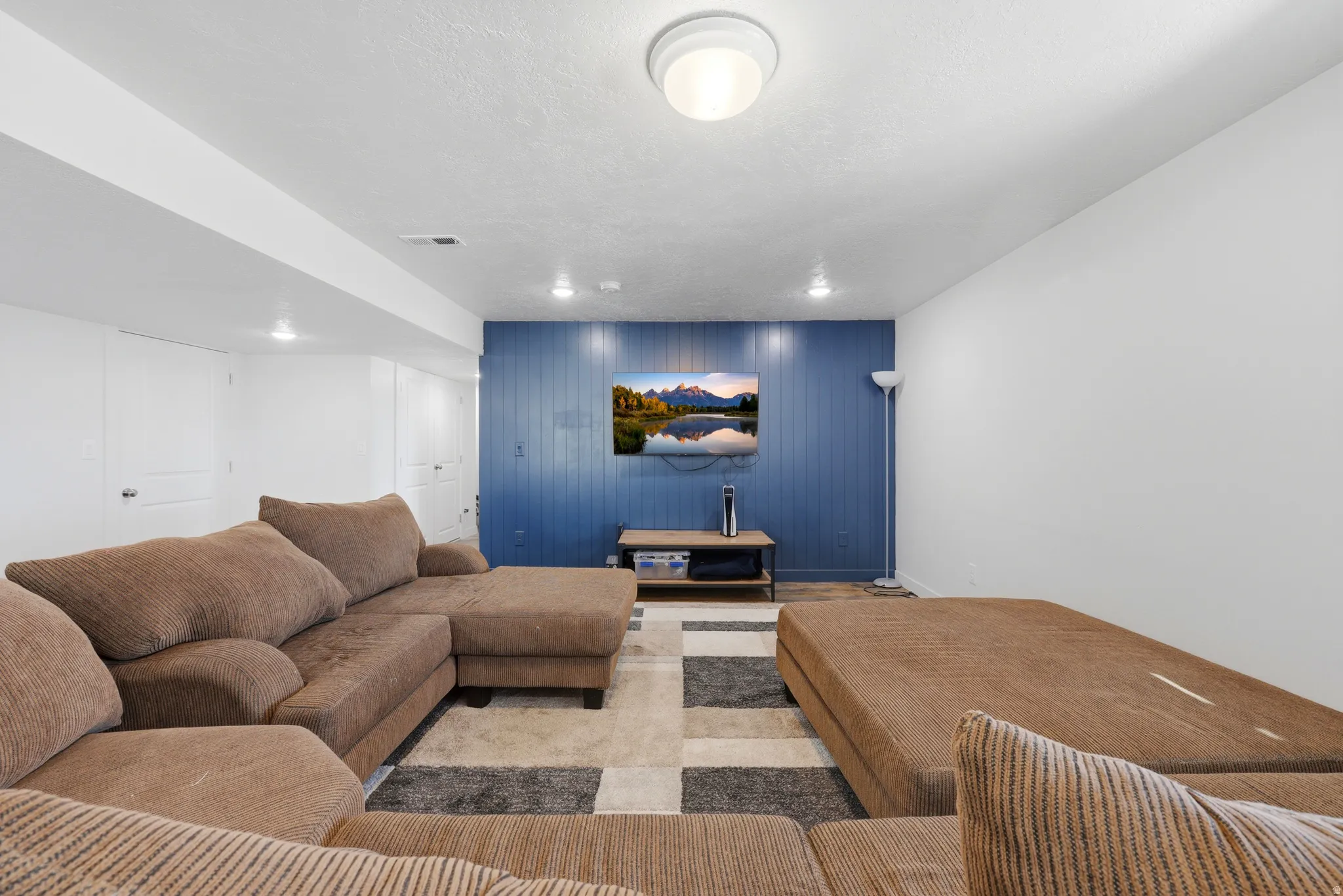 Recreation room featuring a paneled accent wall, recessed lighting, and a neutral color palette