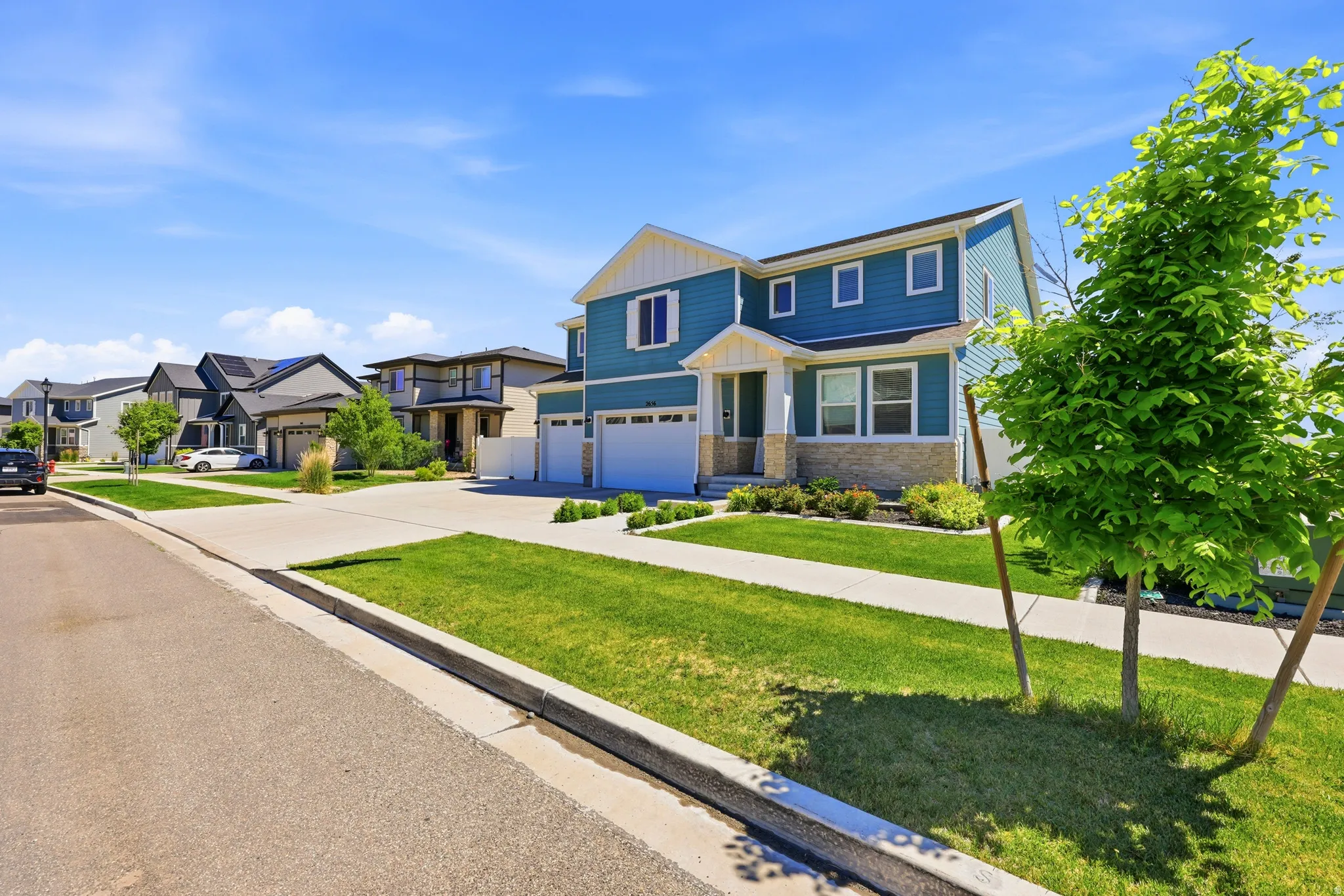 Two-story home featuring blue siding, white trim, and stone accents