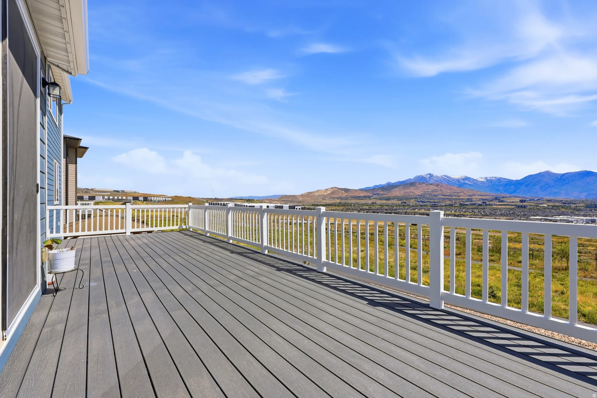 Expansive outdoor deck featuring dark composite decking and white railings